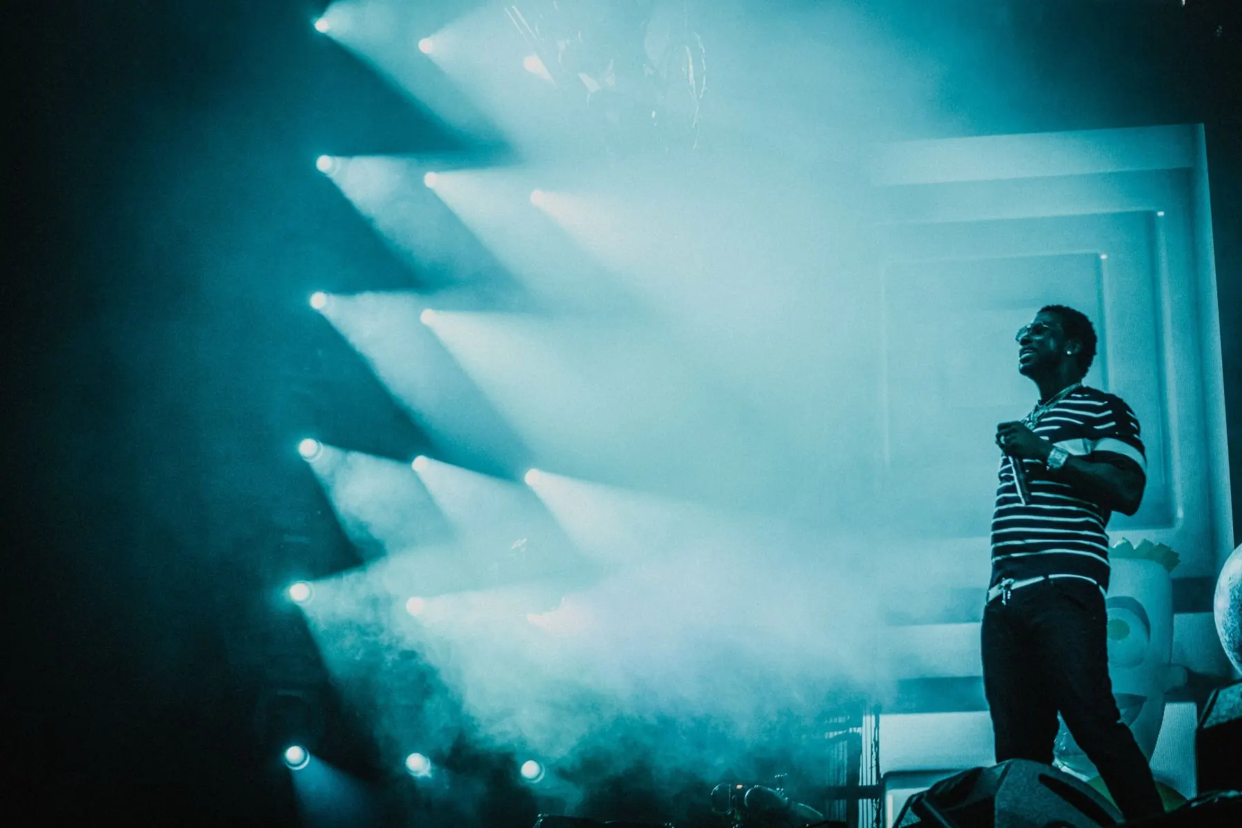 A performer on stage under blue lights